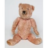 A rare pre-war pink Chiltern teddy, with clear glass eyes, sewn nose and mouth, and cloth pads,