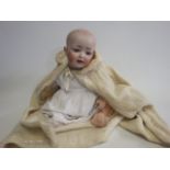 A bisque socket head character baby doll, with blue glass sleeping eyes, open mouth, teeth and