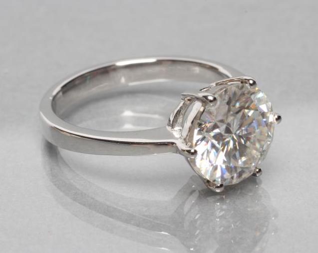 A MOISSANITE SOLITAIRE RING, the brilliant cut stone of approximately 2.5cts, claw set to a plain