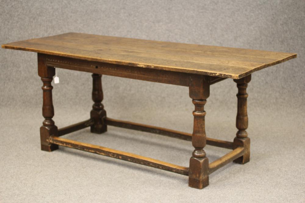 A JOINED OAK DINING TABLE, late 17th century and later, the associated three plank top on moulded