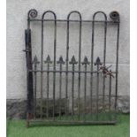 A WROUGHT IRON PEDESTRIAN GATE of multi barred form, the upper bars rounded at the top, the lower