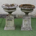 A PAIR OF HADDONSTONE "REGENCY" URNS, the shallow half fluted bowl with egg and dart moulded rim and