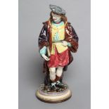 A CONTINENTAL MAJOLICA FIGURE, late 19th century, modelled as a gentleman wearing a grey hat, fur