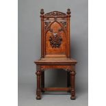 A VICTORIAN GOTHIC OAK HALL CHAIR, the arched back with turned uprights and foliate carved finials