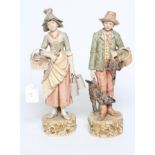 A PAIR OF ROYAL DUX FIGURES, early 20th century, modelled as a young hunter with a basket over his