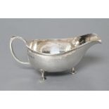 AN ARTS AND CRAFTS SILVER SAUCEBOAT, maker A.E. Jones, Birmingham 1923, the planished oval bowl with