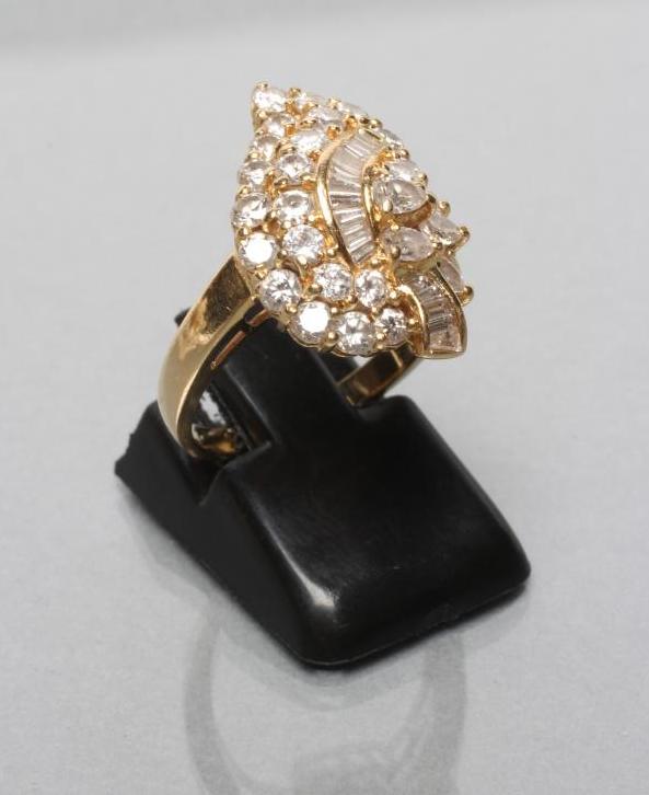 A DIAMOND COCKTAIL RING, the leaf shaped panel variously set with baguette and brilliant cut