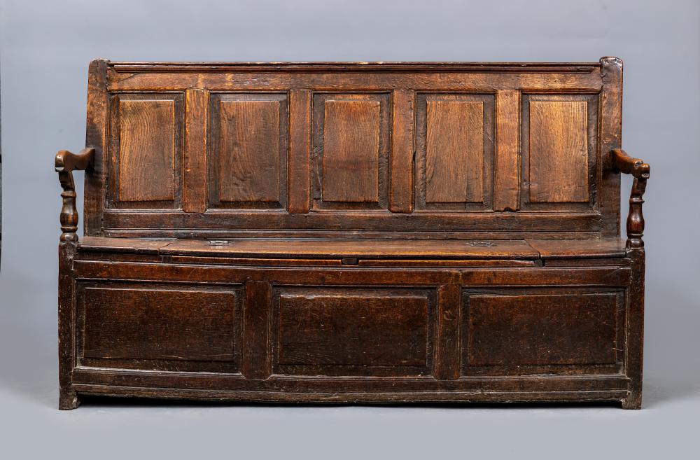 A GEORGIAN OAK BOX SETTLE, mid/late 18th century, the raked back with five fielded panels, mildly