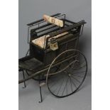 A VICTORIAN TWO WHEEL DOG CART, the ebonised monogrammed panelled body with front and rear seats and