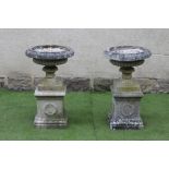 A PAIR OF COMPOSITION STONE URNS, of half fluted shallow form with egg and dart moulded rim and