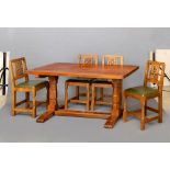 A DEREK SLATER ADZED OAK DINING TABLE, the rounded oblong plank top on trestle support with turned