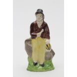 A CREAMWARE TOY FIGURE OF A SAILOR, c.1800, modelled wearing a black hat, brown jacket and yellow