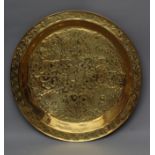 A LARGE ARTS AND CRAFTS BRASS CIRCULAR PLAQUE, the dished centre embossed with flowers and