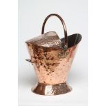A VICTORIAN COPPER COAL SCUTTLE of helmet form with swing loop handle and embossed with Arts and
