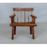 A PRIMITIVE ASH COMB BACK ARMCHAIR, 19th century, possibly Irish/Welsh, with curved top rail,
