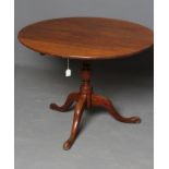 A GEORGIAN OAK SUPPER TABLE, the circular tilt top on turned vase stem, the tripod base on