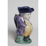 A MAK MERRY EARTHENWARE TOBY JUG AND COVER, 1930's, wearing a blue hat, lilac jacket over flower