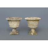 A PAIR OF HADDONSTONE FRENCH PATTERN COMPOSITION URNS, the tapering bowl moulded with a trailing