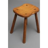A ROBERT THOMPSON ADZED OAK STOOL, the waisted rounded oblong seat top with carved mouse trademark