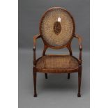 A GEORGIAN MAHOGANY HEPPLEWHITE STYLE ELBOW CHAIR, early 20th century, the oval caned back centred