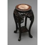 A CHINESE PADOUK WOOD JARDINIERE STAND, early 20th century, the circular top inset with red