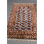 A BOKHARA DESIGN RUG, the deep blue field with three rows of repeating guls in navy blue, red and