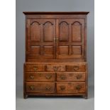 A GEORGIAN OAK CLOTHES PRESS, mid 18th century, the moulded cornice over a pair of doors with arched