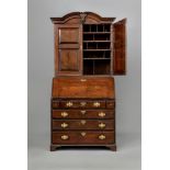 A GEORGIAN OAK BUREAU BOOKCASE, mid 18th century, the arched moulded cornice centred by a carved