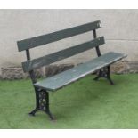 A VICTORIAN PARK BENCH, with open twin plank back, similar hinged seat, on square section end