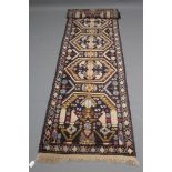 A PERSIAN STYLE RUNNER, with five lozenge shaped guls in ivory, rose pink, red and blue, on a navy