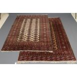 A PAIR OF BOKHARA DESIGN RUGS, the camel field with three rows of repeating guls in navy blue, red