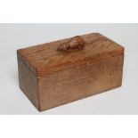A ROBERT THOMPSON ADZED OAK TRINKET BOX of oblong form, the detachable lid surmounted by a carved