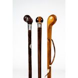 A BAMBOO WALKING CANE, the rosewood grip carved as a human head, "silver" ferrule and similar patera