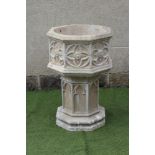 A COMPOSITION STONE PLANTER of octagonal form, the panelled sides featuring stylised flower heads,