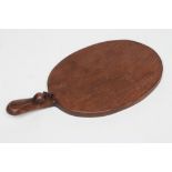 A ROBERT THOMPSON ADZED OAK CHEESE BOARD, the oval board with long handle with carved mouse