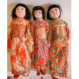 Three large oriental dolls, with composition heads, composition lower limbs, and highly decorative