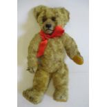 A Chad Valley teddy, 1920s, with swivel joints, sewn nose, amber eyes, felt pads, orange plush,