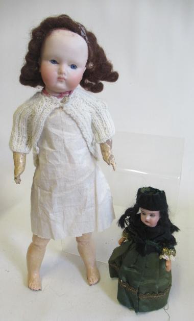 Two bisque socket head dolls comprising a 7 1/2" doll with blue glass sleeping eyes, open mouth