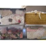 Three boxes and a basket of dolls cloths, linen and decorative flowers (Est. plus 21% premium inc.
