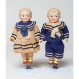 A pair of Armand Marseille googly eyed bisque socket head dolls, with moulded hair and sideways