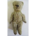 A pre-war teddy, with sewn nose, one amber eye, cloth pads, light orange plush and swivel joints,
