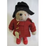 A Paddington Bear, with grey plush, moulded plastic nose, black felt hat, red felt coat, red