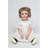 A Kammer & Reinhardt bisque socket head flirty doll, with brown glass sideways glancing eyes,