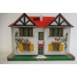 A Triang dolls house, with white walls painted with vines, red roof, metal door, windows and pullout