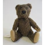 A pre-war Steiff jointed brown teddy, straw filled with sewn nose, amber eyes, felt pads and