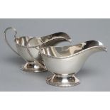 A PAIR OF SILVER SAUCEBOATS, maker Walker & Hall, Sheffield 1936, the oval bowls with cast and