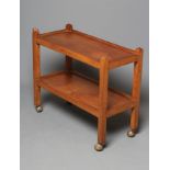 A ROBERT THOMPSON ADZED OAK TEA TROLLEY of oblong two tier form, the square section supports with