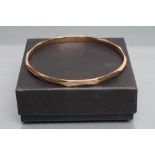 A 9CT GOLD BANGLE of faceted circular form, Birmingham 1924, 19.6g (Est. plus 21% premium inc. VAT)