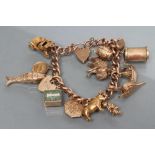 A CURB LINK CHAIN BRACELET, each hollow link stamped 9ct, with padlock fastener and fourteen charms,