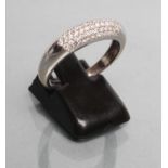 A DIAMOND HALF HOOP RING, the "D" shaped panel pave set with numerous small diamonds to a plain 18ct